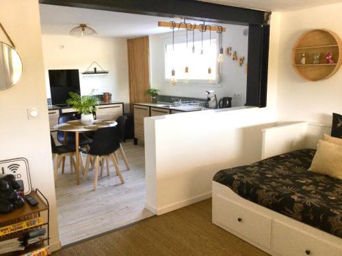 1 dormitorio con 1 cama y cocina con mesa en Au calme proche de la Loire et Nantes, en Saint-Julien-de-Concelles