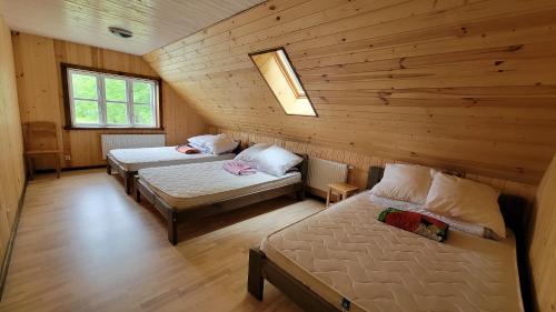 Zimmer mit 2 Betten in einem Blockhaus in der Unterkunft Sodyba Paštys Poilsinė Su Pirtim in Vozgėliai