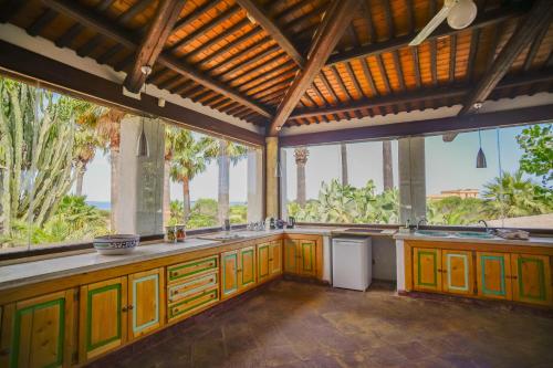a kitchen with yellow cabinets and a view of the ocean at Kite Hostel Stagnone in Marsala