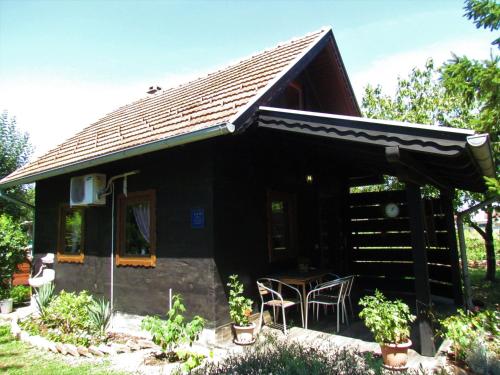 a small black house with a table and chairs at House for rest Juliet in Velika Gorica