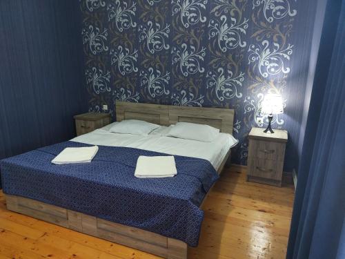 a bedroom with a bed with two towels on it at Lakeside Green Balcony Home in Tskaltubo
