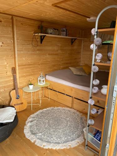 a room with a bunk bed and a guitar at V dedine a predsa mimo nej v maringotke na samote in Dechtice