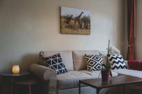 a living room with a couch and a picture of giraffes at Moderne Wohnung im Herzen der Natur - Ingo's Dream in Bäbelin