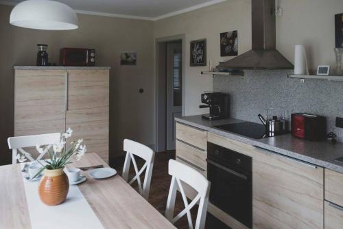 a kitchen with a wooden table and a counter top at Moderne Wohnung im Herzen der Natur - Ingo's Dream in Bäbelin