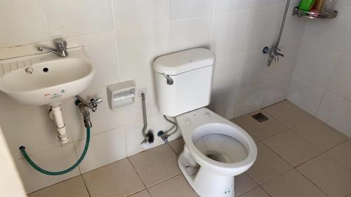a bathroom with a toilet and a sink at Golden Kirins Beach Resort in Lian
