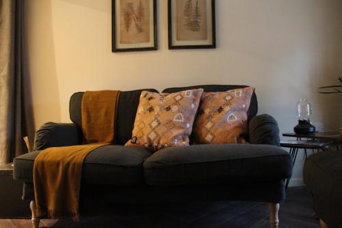 a couch with pillows on it in a living room at Carpenters Rest, Wighton Near Wells Next The Sea in Wighton