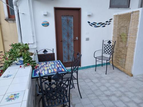 a patio with chairs and a table and a door at Cala Di Luna House in Vietri sul Mare