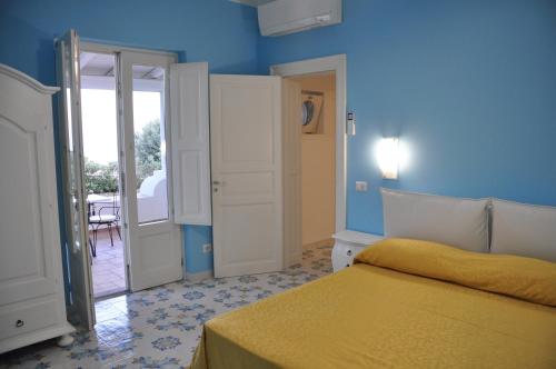 1 dormitorio con cama y pared azul en Case Vacanze Margherita en Lipari