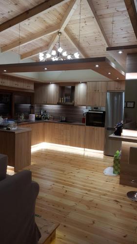 a large kitchen with wooden floors and a wooden ceiling at Vila Thailanda in Katakolo in Pýrgos