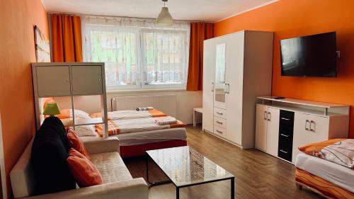 Habitación con 2 camas, sofá y TV. en Ubytování Lednice, en Lednice