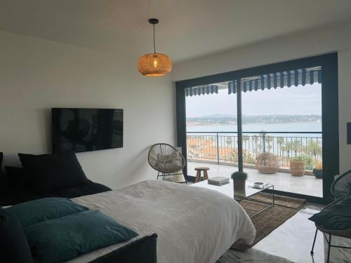 Bandol Appartement Luxe vue mer époustouflante en face des plages في باندول: غرفة نوم مع سرير وإطلالة على المحيط