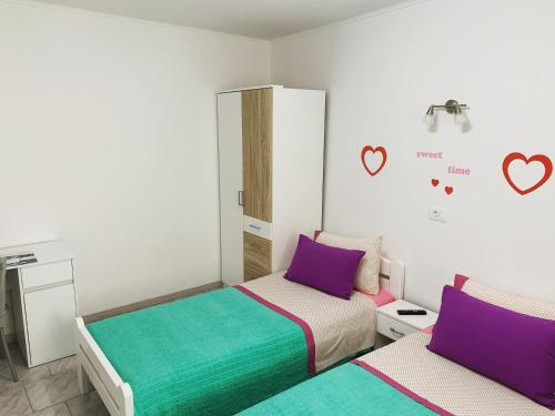 1 dormitorio con 2 camas de color morado y verde en Holiday house Dalinda, en Dražice