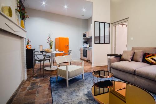 a living room with a couch and a table at room five - parking, balnéothérapie, place nationale, un havre de paix in Montauban