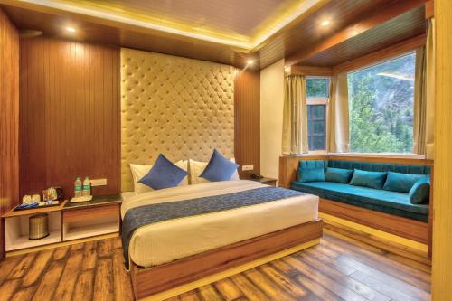 a bedroom with a bed and a window and a couch at Baan by Snow City Farm in Vashisht
