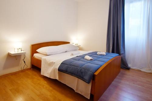 a bedroom with a bed with a blue blanket at Apartman Krstaš- Gonar in Supetarska Draga