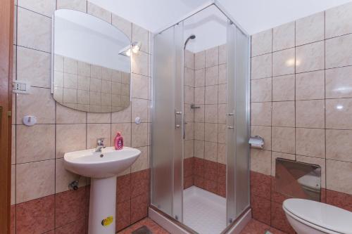 un baño con ducha y lavabo en Apartments Radović, en Labin