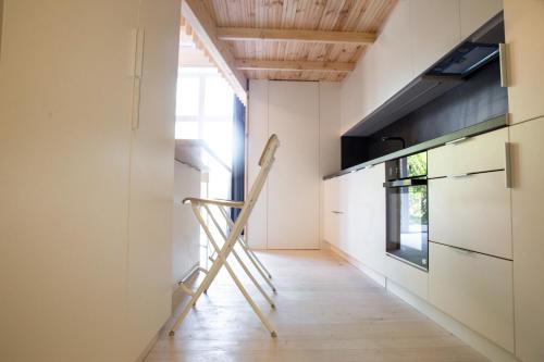 a kitchen with a ladder in the middle of a room at Alyvų Namai Nida in Nida