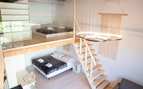 a tiny house with a staircase and a bed at Alyvų Namai Nida in Nida