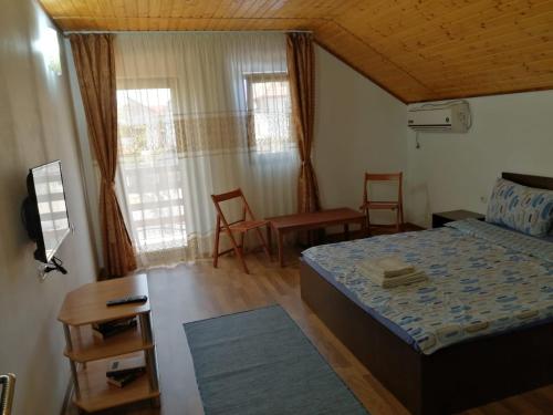 a bedroom with a bed and a table and chairs at Casa David&Alexia 2 Mai in 2 Mai