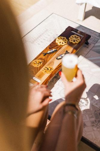 a woman sitting at a table with a cup of coffee at MUSE Saint Tropez - Small Luxury Hotels of the World in Saint-Tropez