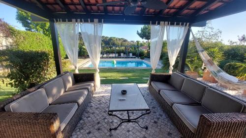 a patio with couches and a table and a pool at VILLA DA FONTE - BY MECO in Alfarim