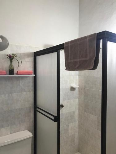 a shower with a glass door in a bathroom at La Hacienda in San Gil