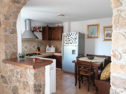 a kitchen with a refrigerator and a table at Casa vacanze Lilly in Teulada