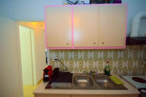 a kitchen with a sink and a pink cabinet at Eclectic Apartment with Stunning Seaview in Porto Rafti
