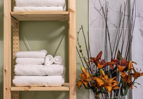 a wooden towel rack with towels and a vase of flowers at Adorable private suite with indoor fire place in Cochrane