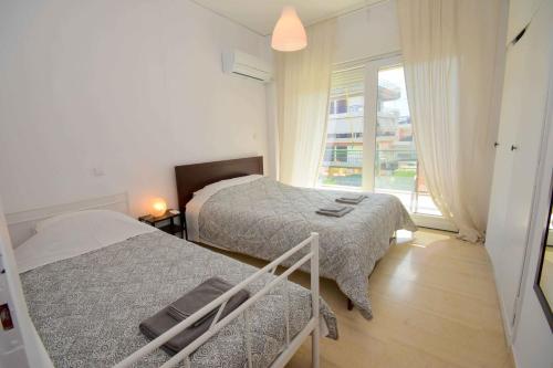 a bedroom with two beds and a window at Eclectic Apartment with Stunning Seaview in Porto Rafti