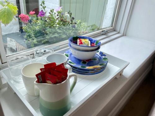 a window sill with a table with cups and presents at South Road Room in Aberystwyth