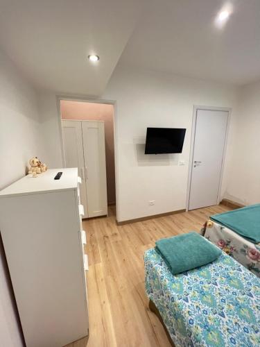 a room with two beds and a flat screen tv at Alla Scalinata del Teatro Rossetti confort suites parcheggio in Trieste