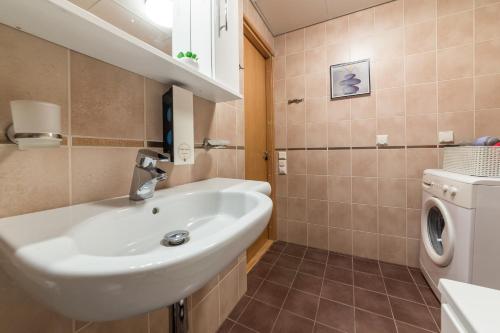 a bathroom with a sink and a washing machine at Solar Apartments - Foorum Center in Tallinn