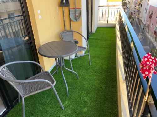 a table and chairs on a balcony with green grass at Diego´s Home in Arona