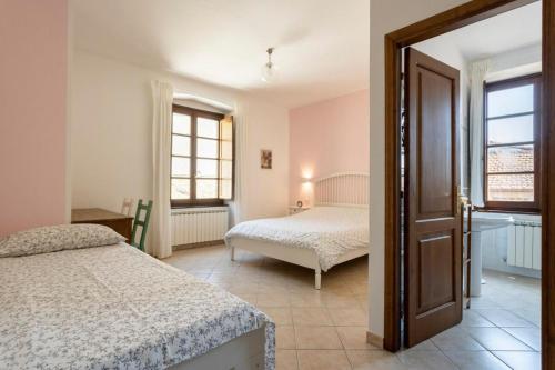 1 dormitorio con 2 camas y ventana en La Dimora del Borgo Antico - Holiday House in Tuscany Lunigiana near 5 Terre, WiFi, Panoramic Terrace, en Fivizzano