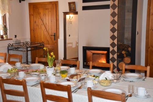 a dining room with a table and a fireplace at Gosciniec Pod Debem in Trzciel