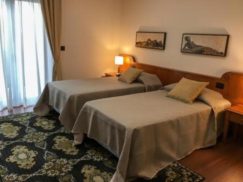 um quarto de hotel com duas camas e uma janela em Erania em Sala Consilina