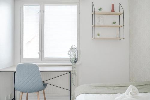a bedroom with a desk and a chair and a window at West Coast Hideaway in Pietarsaari