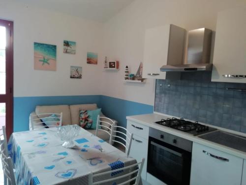 una cocina con una mesa y una estufa en Prendas Antigas - vacanze a Teulada, en Teulada