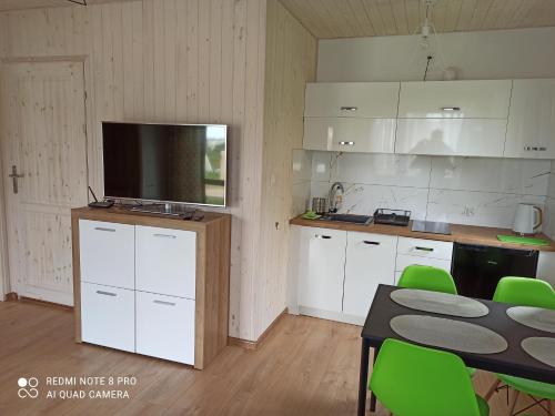 a kitchen with white cabinets and a tv on a counter at Domki-Apartamenty Hals in Władysławowo