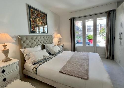 een slaapkamer met een groot wit bed en een raam bij 120m2 avec deux terrasses ensoleillées à Biarritz in Biarritz