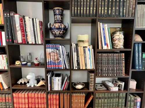 une étagère remplie de livres et d'un vase dans l'établissement 120m2 avec deux terrasses ensoleillées à Biarritz, à Biarritz