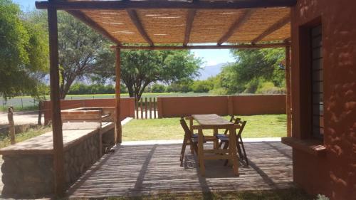 a wooden pergola with a table and chairs on a patio at Cabañas Bella Vista in San Carlos