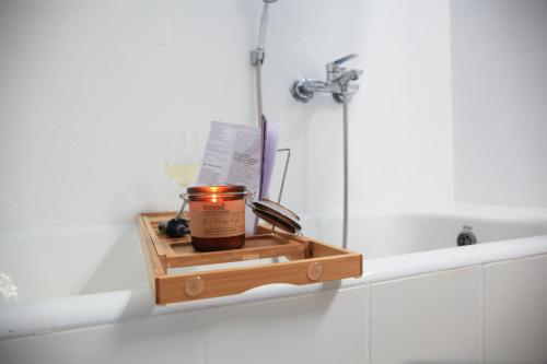 a candle on a wooden tray next to a bath tub at LAXD Summer House by Homebrain in Mákri