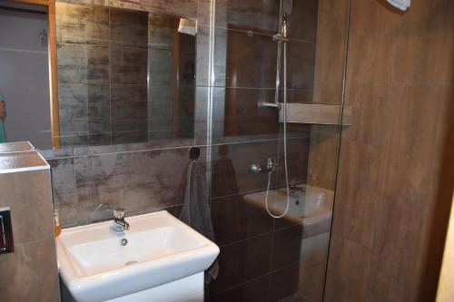 a bathroom with a sink and a shower at Gosciniec Pod Debem in Trzciel