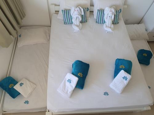 - un lit blanc avec des oreillers bleus et blancs dans l'établissement Condominio Nui Supreme - By Maya - Muro Alto - Porto de Galinhas, à Porto de Galinhas