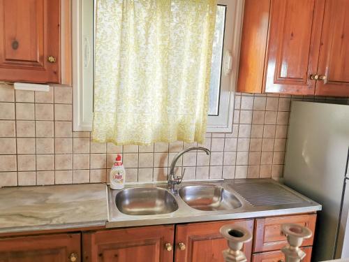 eine Küche mit einem Waschbecken und einem Fenster in der Unterkunft MARINA in Perama