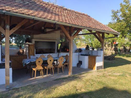 a patio with a table and chairs under a pavilion at Róka's- Farm in Šupljak