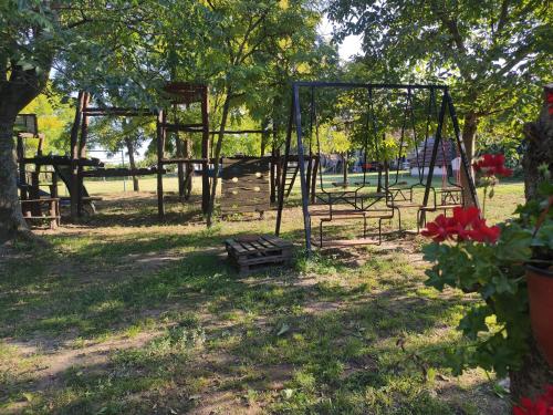 a park with a swing set in the grass at Róka's- Farm in Šupljak