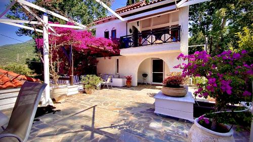 ein Haus mit einer Terrasse mit Blumen im Hof in der Unterkunft Spiti Galini, "Haus der Zufriedenheit" in Paralía Sergoúlas